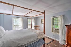 a bedroom with a canopy bed and two windows at Charlemont Retreat on Chickley River with EV Charger in Charlemont