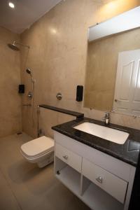 a bathroom with a sink and a toilet and a mirror at Amizunie's Boutique Hotel by SSAZ Hospitality in Udaipur