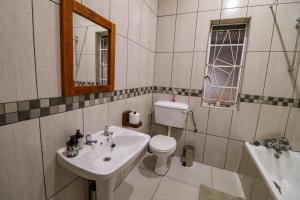 a bathroom with a sink and a toilet and a mirror at The Honeycomb 2 in Kimberley