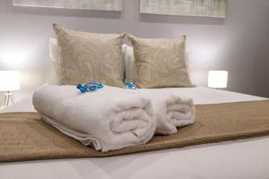 een bed met een stapel witte handdoeken erop bij The Honeycomb 2 in Kimberley