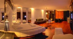 um quarto de hotel com uma cama grande e uma sala de estar em Gran Motel Dubai em Caxias do Sul