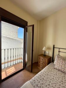 - une chambre avec un lit et une fenêtre avec un balcon dans l'établissement LaFrenchTouch - Relájate y desconecta al pueblo, à Villanueva de Tapia