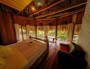 - une chambre avec un lit et un canapé dans l'établissement Eco Hotel Sak Nok, à Lacanjá