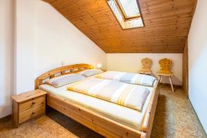 a bedroom with a wooden bed and a skylight at Unterversanthof - Große Ferienwohnung für bis zu 6 Personen in Naturno