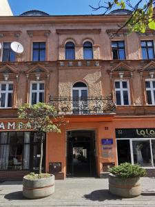 a large brick building with a tree in front of it at Dworcowa Centrum Apartament in Bydgoszcz