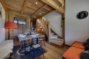 ein Esszimmer mit einem Tisch und einer Treppe in der Unterkunft Appartement esprit chalet - splendide vue montagne in Val dʼIsère