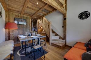 a dining room with a table and a staircase at Appartement esprit chalet - splendide vue montagne in Val-d'Isère