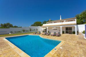 eine Villa mit einem Pool vor einem Haus in der Unterkunft Villa Citrinos by Villa Plus in Almancil