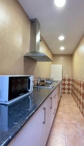 uma cozinha com um micro-ondas e uma bancada em LaFrenchTouch - Escapada rural en una coqueta casa em Villanueva de Tapia