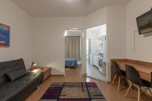 ein Wohnzimmer mit einem Sofa und einem Tisch in der Unterkunft Apartamento no Brás com Elevador in São Paulo