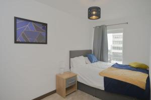 a bedroom with a bed and a window at Stylish, 2-bedroom flat, Central Southend Flat, 11th floor in Southend-on-Sea