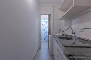 uma cozinha branca com um lavatório e uma janela em Apartamento no Brás com Elevador em São Paulo