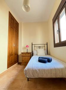 a bedroom with a bed with a blue pillow on it at LaFrenchTouch - Escapada rural en una coqueta casa in Villanueva de Tapia