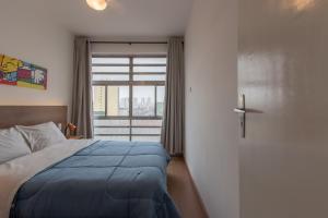 ein Schlafzimmer mit einem Bett und eine Tür mit einem Fenster in der Unterkunft Apartamento no Brás com Elevador in São Paulo