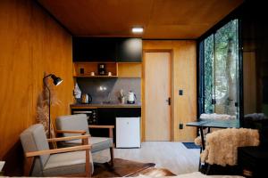 uma cozinha com um frigorífico, uma mesa e cadeiras em Reserva Alpes em São Francisco de Paula