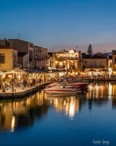 un gruppo di barche ormeggiate in un porto di notte di Jason Hotel Apartments a Rethymno