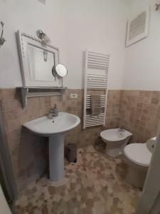 a bathroom with a sink and a toilet and a mirror at Ballerina Bianca bed & breakfast in Grottazzolina