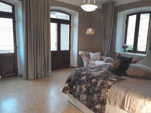 a bedroom with a bed and a chair and windows at Ballerina Bianca bed & breakfast in Grottazzolina