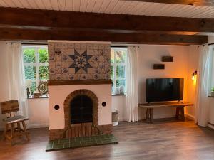 a living room with a fireplace and a tv at Das Atelier in Krummhörn