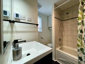 a white bathroom with a sink and a shower at Le Repère du Mont-Saint-Anne in Beaupré