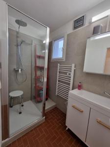 a bathroom with a shower and a sink and a stool at Magnificent apartment typical of Saintes-Maries-de-laMer in Saintes-Maries-de-la-Mer