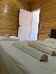 a row of beds in a room with a window at Bujtina Arturi in Valbonë