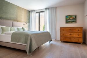 a bedroom with a bed and a dresser and a window at Transmontana in Vols am Schlern