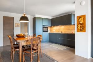 Una cocina y un comedor con mesa y sillas de madera. en Transmontana, en Vols am Schlern
