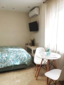 una camera con letto, tavolo e sedie di Emerald Mini Suite:Your deluxe studio in Kalamaria a Salonicco
