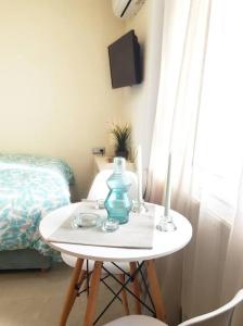 a small table with a blue vase and two candles on it at Emerald Mini Suite:Your deluxe studio in Kalamaria in Thessaloniki