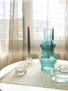 a table with a blue vase and two glasses on it at Emerald Mini Suite:Your deluxe studio in Kalamaria in Thessaloniki