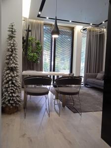 uma sala de jantar com mesa e cadeiras e uma árvore de Natal em Apartament Tempo per Te em Zakopane