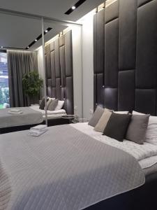 sypialnia z 2 łóżkami i dużym lustrem w obiekcie Apartament Tempo per Te w Zakopanem