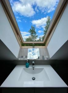 a bathroom with a large window above a sink at Cicha Ostoja in Miłków