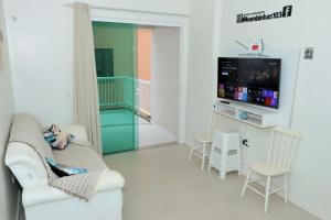 ein Wohnzimmer mit Sofa und Fernseher in der Unterkunft Residencial Açores in Bombinhas