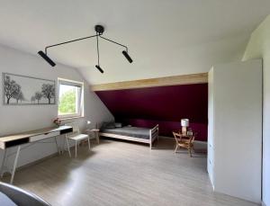 a living room with a couch and a purple wall at Cicha Ostoja in Miłków