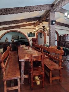 un comedor con una gran mesa de madera y sillas en CASA TURÍSTICA Villa Carmen, CON CHIMENEA, AMPLIA ZONA DE JARDÍN, BARBACOA, PISCINA Y GARAJE, en Arenzana de Abajo