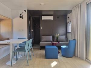 a living room with a table and blue chairs at Charmant et Spacieux Mobil Home in Rocbaron