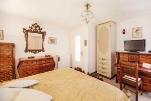 1 dormitorio con 1 cama, vestidor y TV en Dimora Bellavista,garage privato,due piani en San Remo