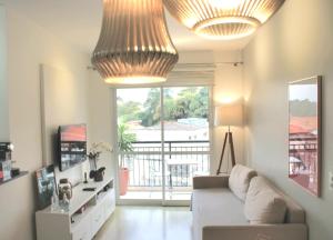 a living room with a couch and two lights at Apartamento 50m2 Hospital Einstein Morumbi in Sao Paulo