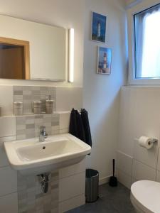 ein weißes Bad mit einem Waschbecken und einem WC in der Unterkunft Ferienunterkunft mit 4 Doppelzimmern in Einbeck!! in Einbeck