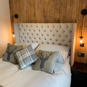 una cama con dos cabezas de ciervo y almohadas en Laburnam Villa - Luxury 4 bedroom accommodation in the heart of Killin en Killin