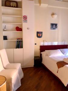 una camera con letto, sedia e libreria di Dame 4 a Bologna