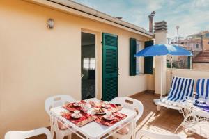 un patio con mesa, sillas y sombrilla en Dimora Bellavista,garage privato,due piani en San Remo