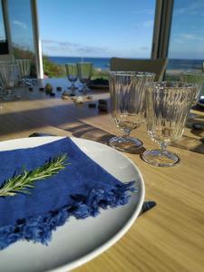 - une table avec une assiette avec une serviette et des verres à vin dans l'établissement Villa Ribera - vue sur mer - Barfleur - 14 personnes, à Montfarville