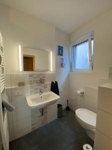 ein weißes Bad mit einem Waschbecken und einem WC in der Unterkunft Ferienunterkunft mit 4 Doppelzimmern in Einbeck!! in Einbeck