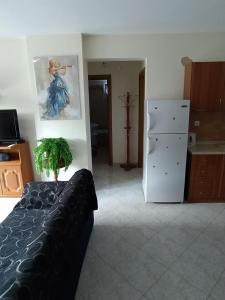 a bedroom with a bed and a white refrigerator at Διαμέρισμα στην πόλη Metamorfosi in Metamorfosi