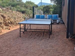 - une table de ping-pong assise au sol avec des chaises bleues dans l'établissement Charmant et Spacieux Mobil Home, à Rocbaron