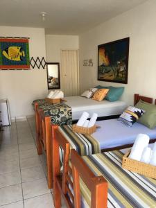 a room with three beds and chairs in it at Pousada Harmonia in Tamandaré +52 photos