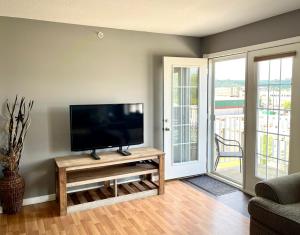 a living room with a flat screen tv on a table at Top Floor Riverfront Condo with Stellar Sunsets! in Fort McMurray